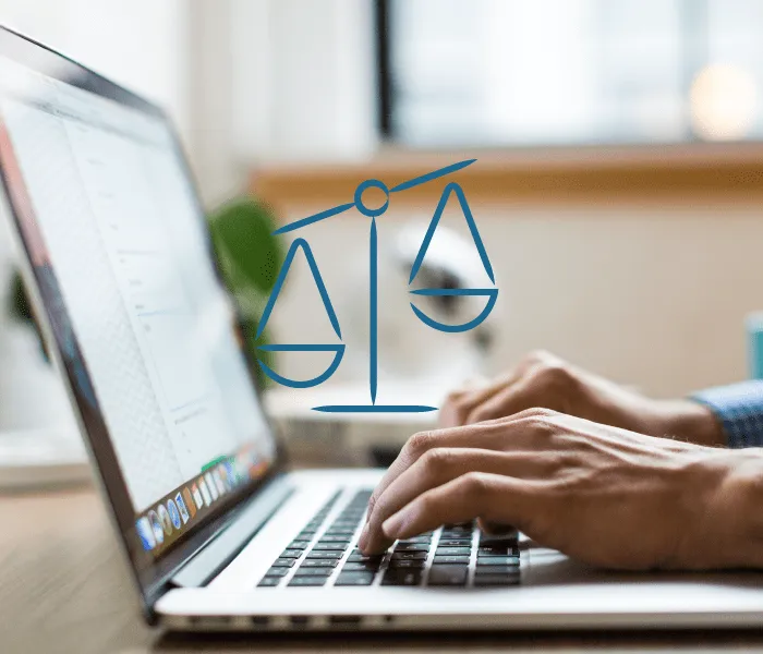 Person typing on a laptop with a superimposed blue scales of justice symbol, indicating legal or judicial work.