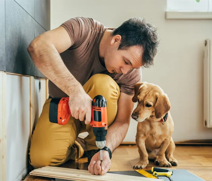 Carpenter drilling wood with power tool.